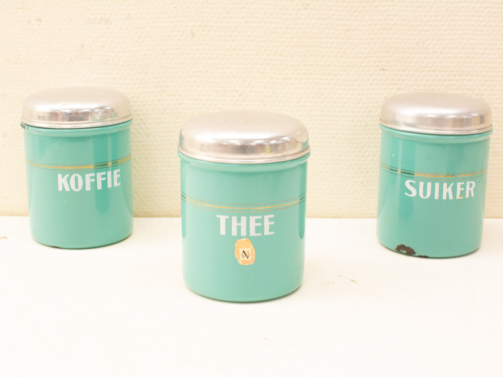 Charming vintage tin canisters for coffee, tea, and sugar in elegant turquoise and gold.