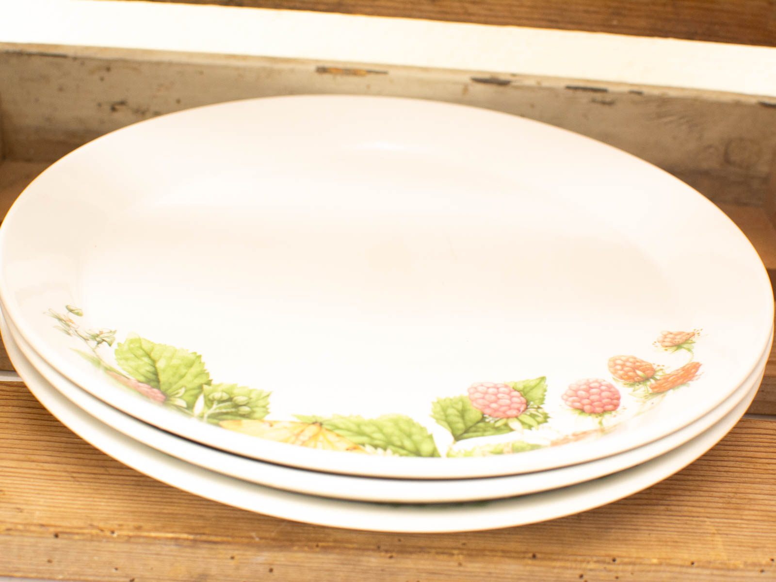 Elegant white plates with raspberry design, perfect for stylish dining and rustic decor.