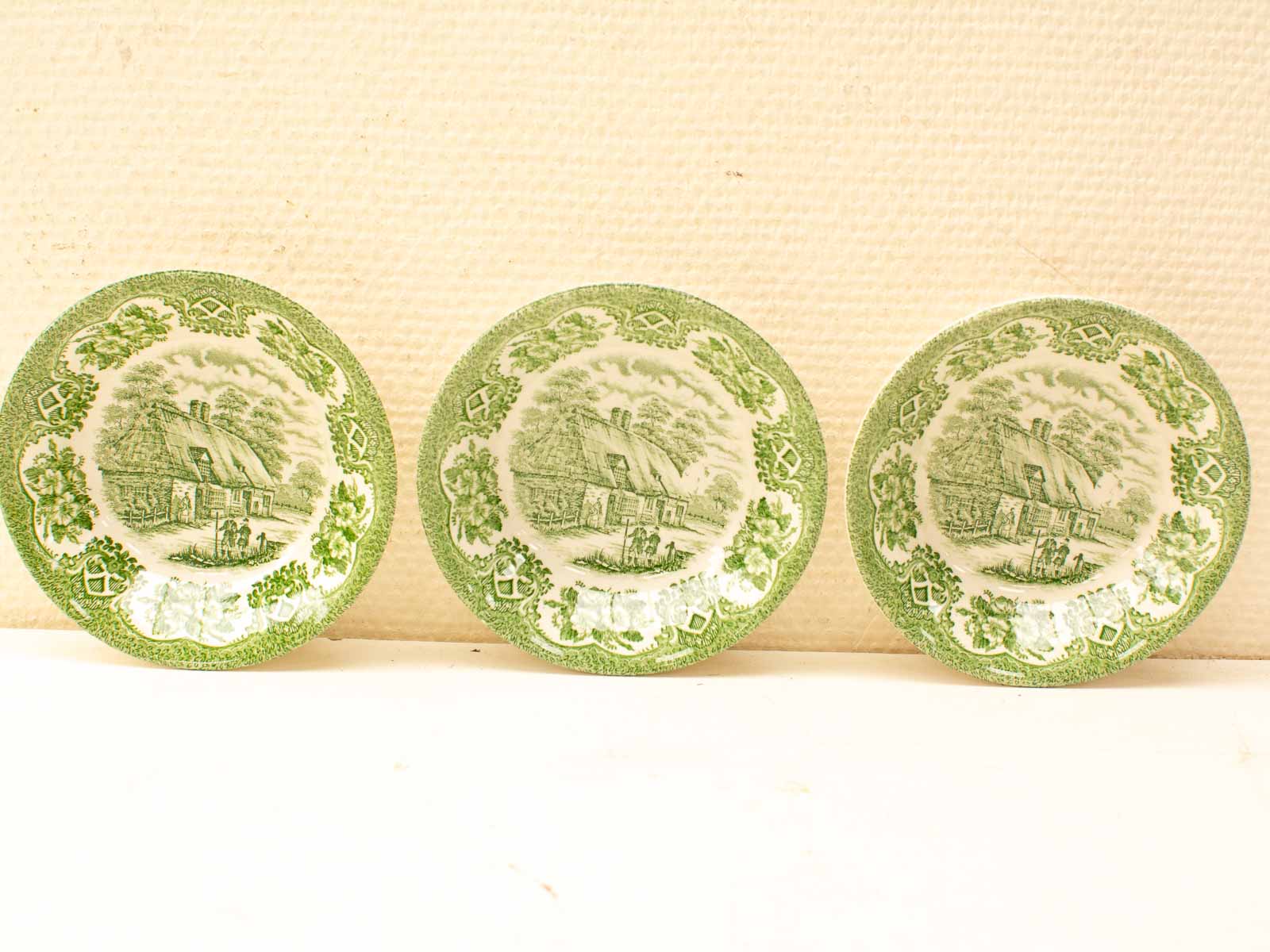 Antique decorative plates with pastoral scenes in green and white—perfect for collectors and display.