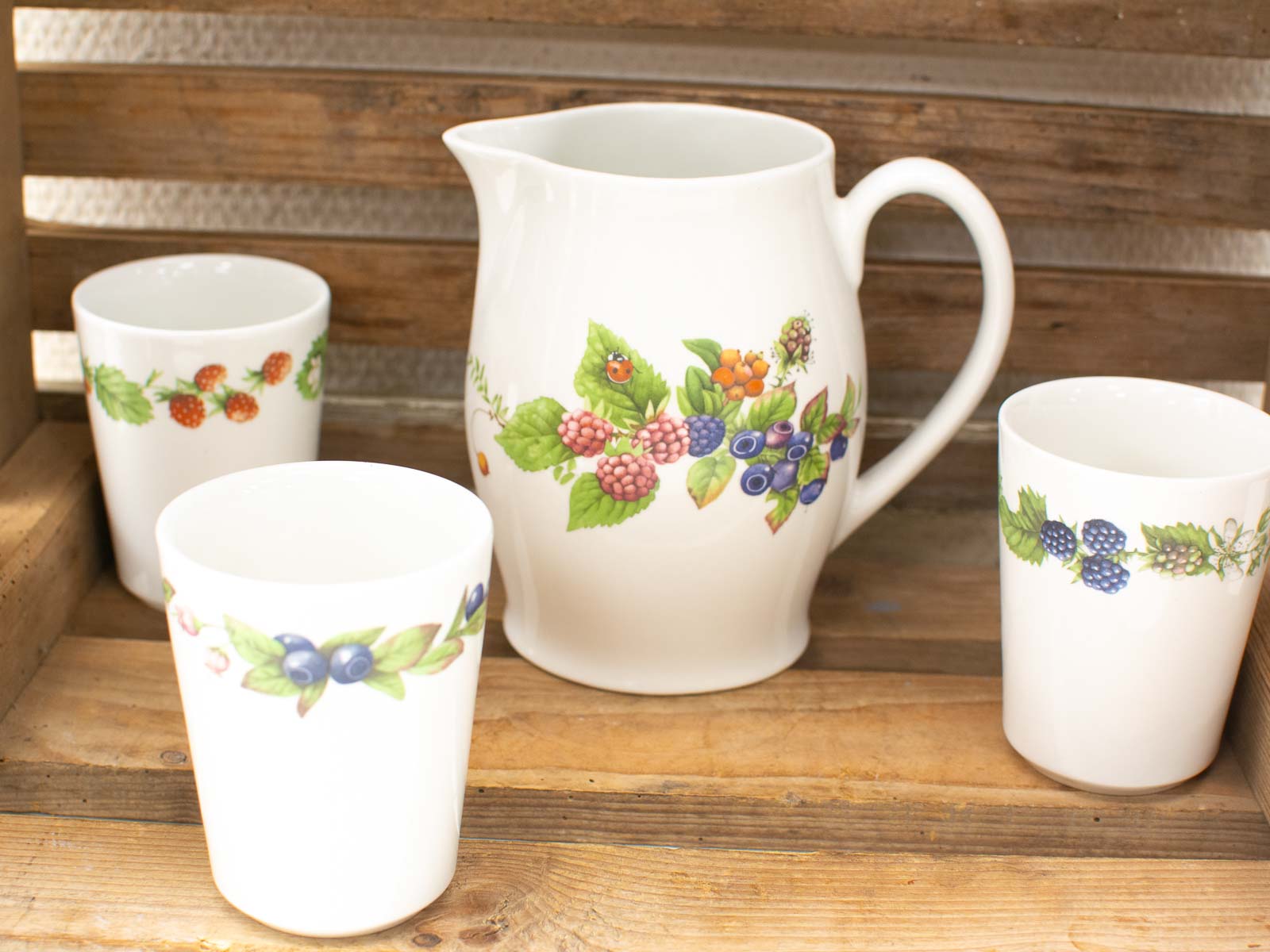 Charming ceramic tableware set with berry motifs for rustic elegance in dining.