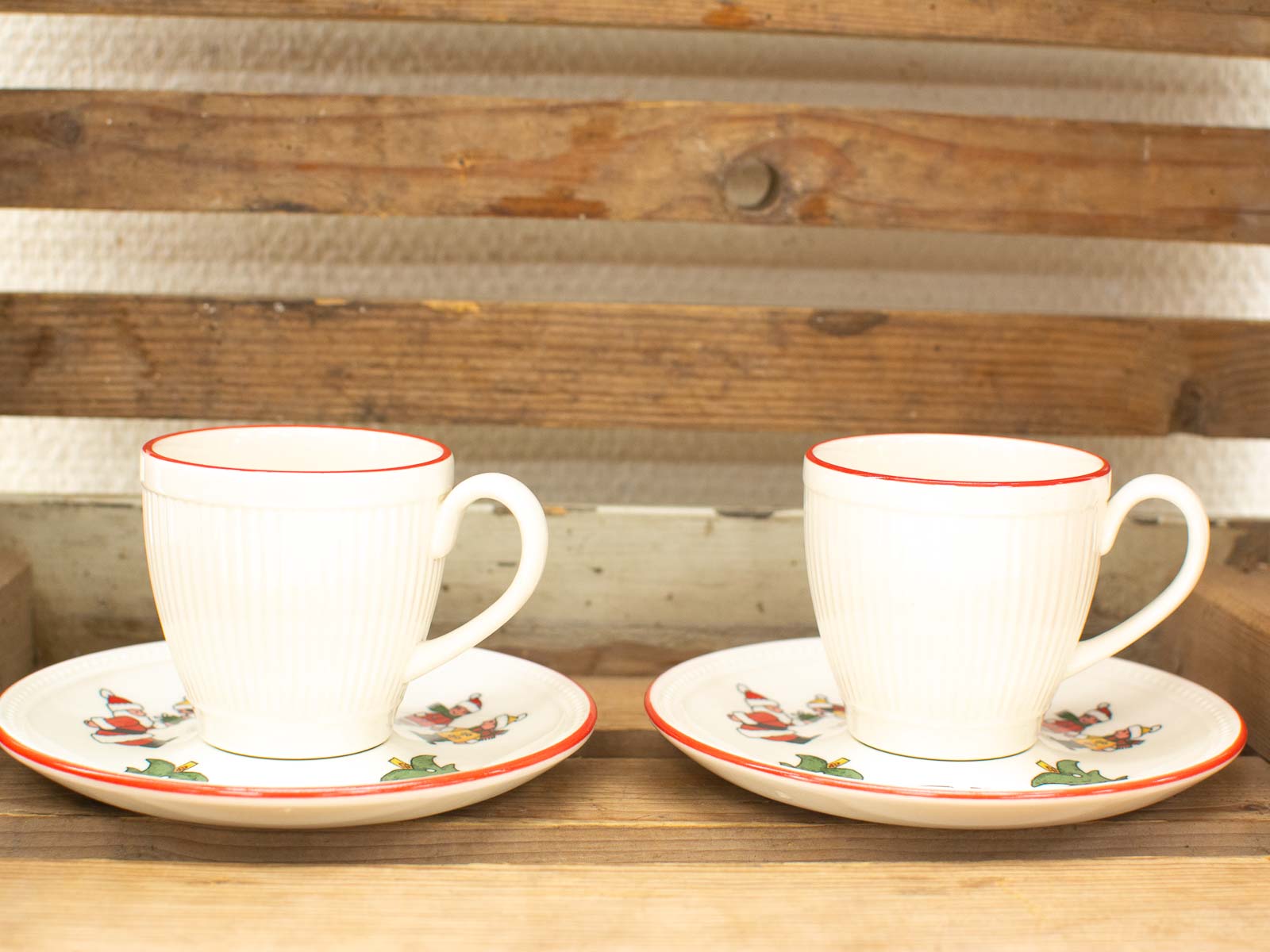 Charming porcelain tea cups with festive saucers on rustic wood, perfect for cozy gatherings.