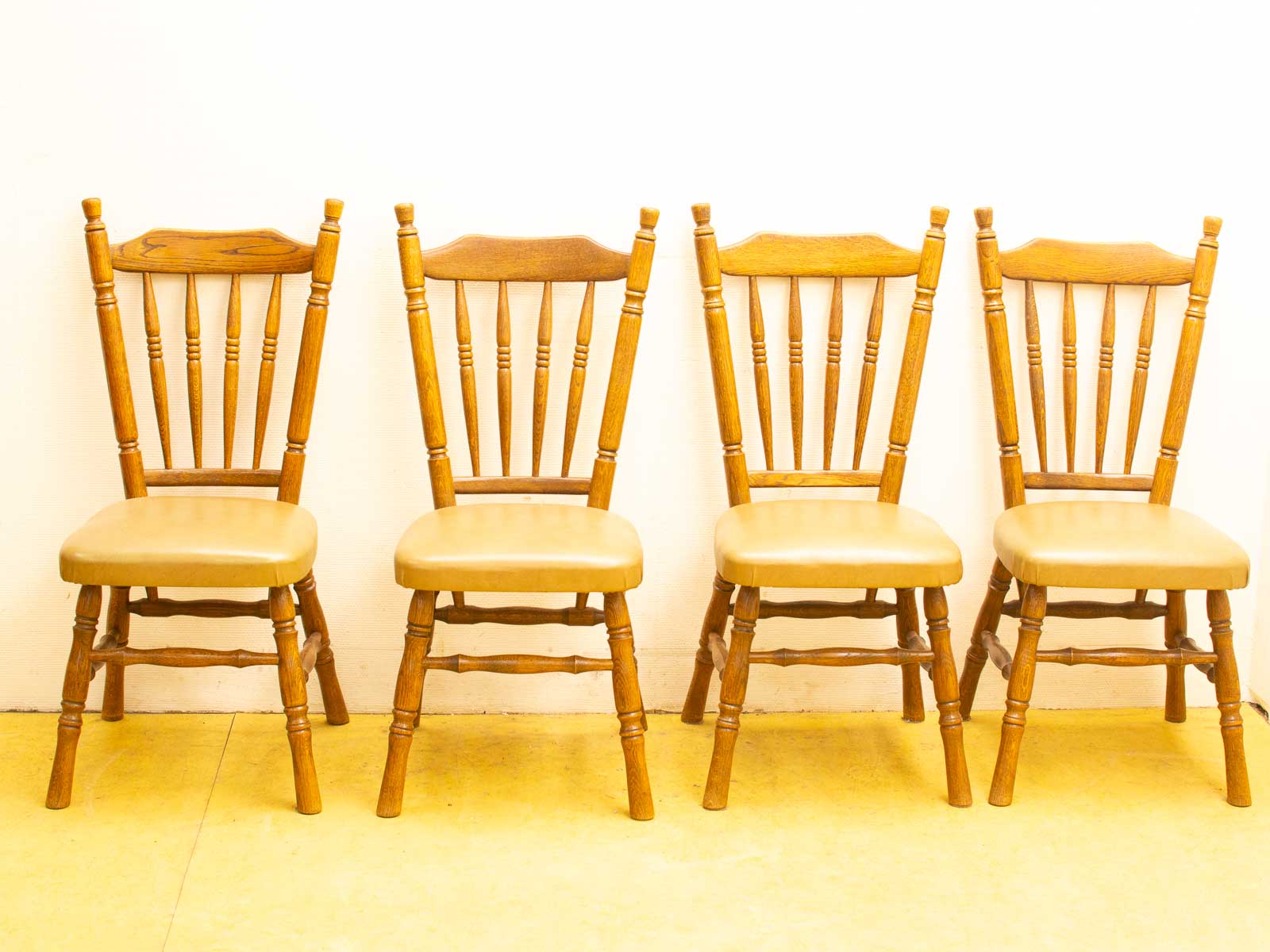 Vintage wooden chairs with spindle backs, upholstered seats, perfect for cozy gatherings and relaxation.