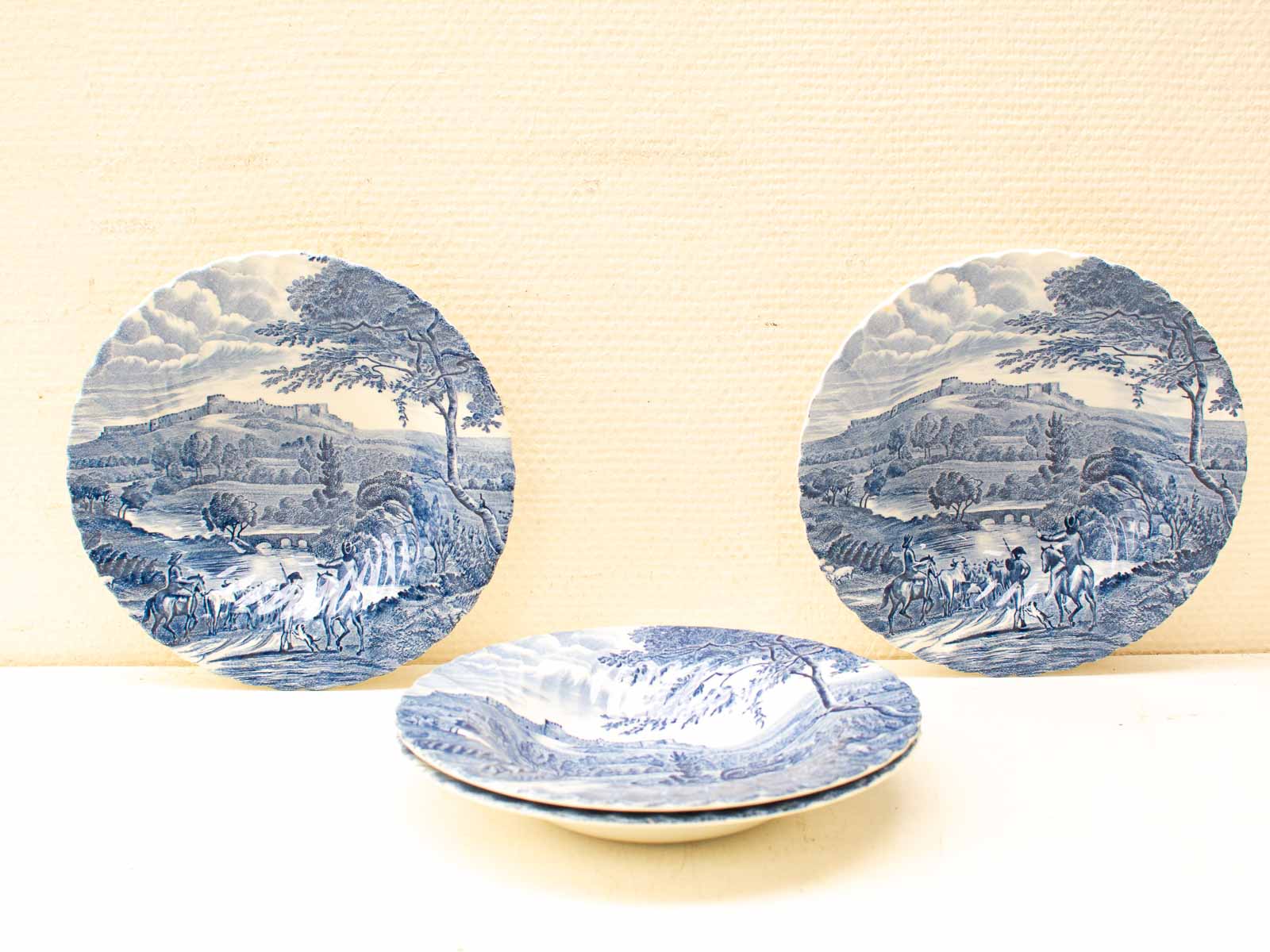 Charming blue-and-white ceramic plates with intricate landscape designs, showcasing traditional craftsmanship.