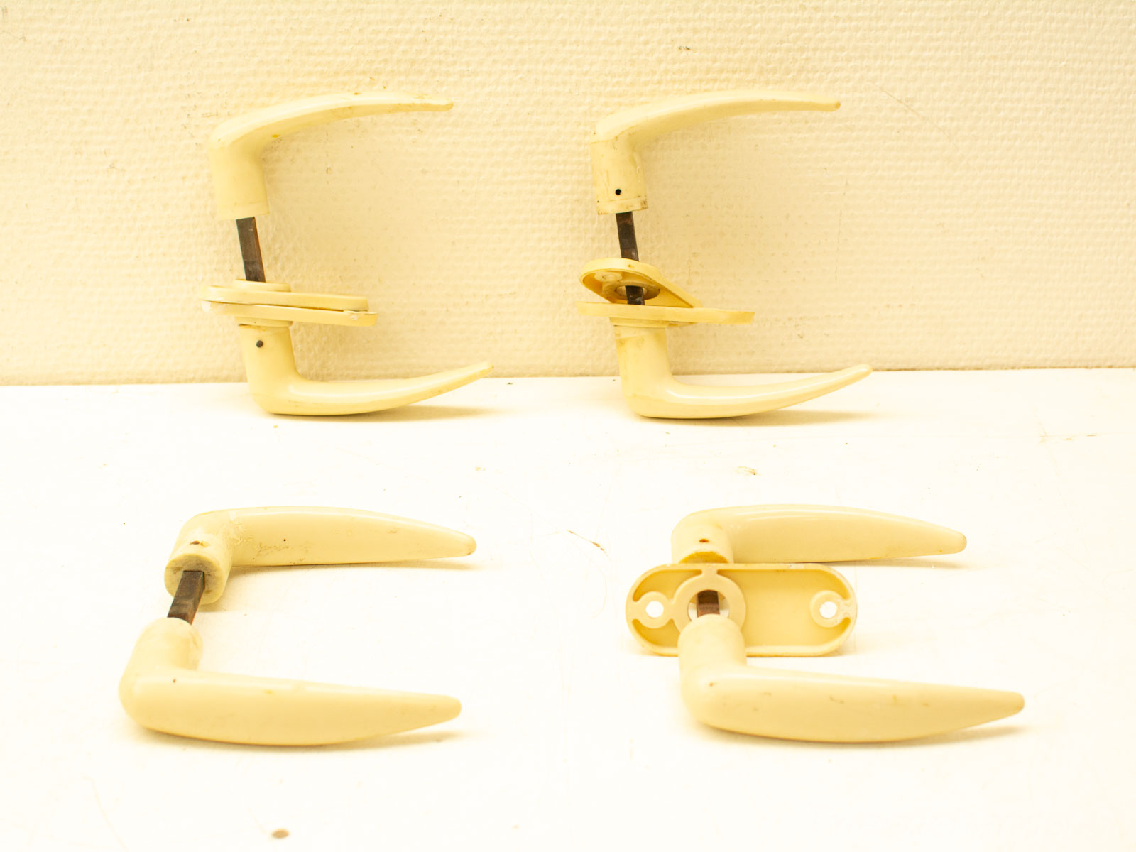 Elegant vintage crème door handles with ergonomic design and durable metal connections.