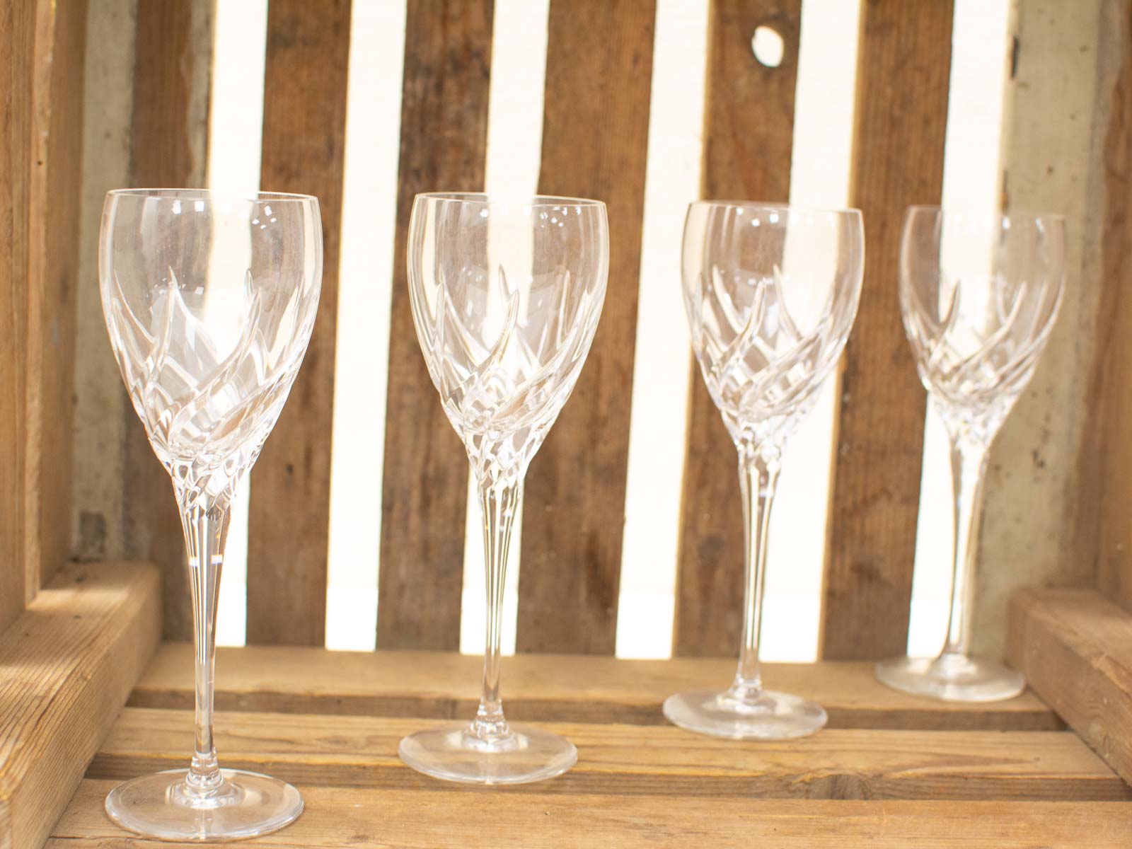 Elegant crystal glasses in a rustic wooden crate, perfect for special occasions and dining experiences.