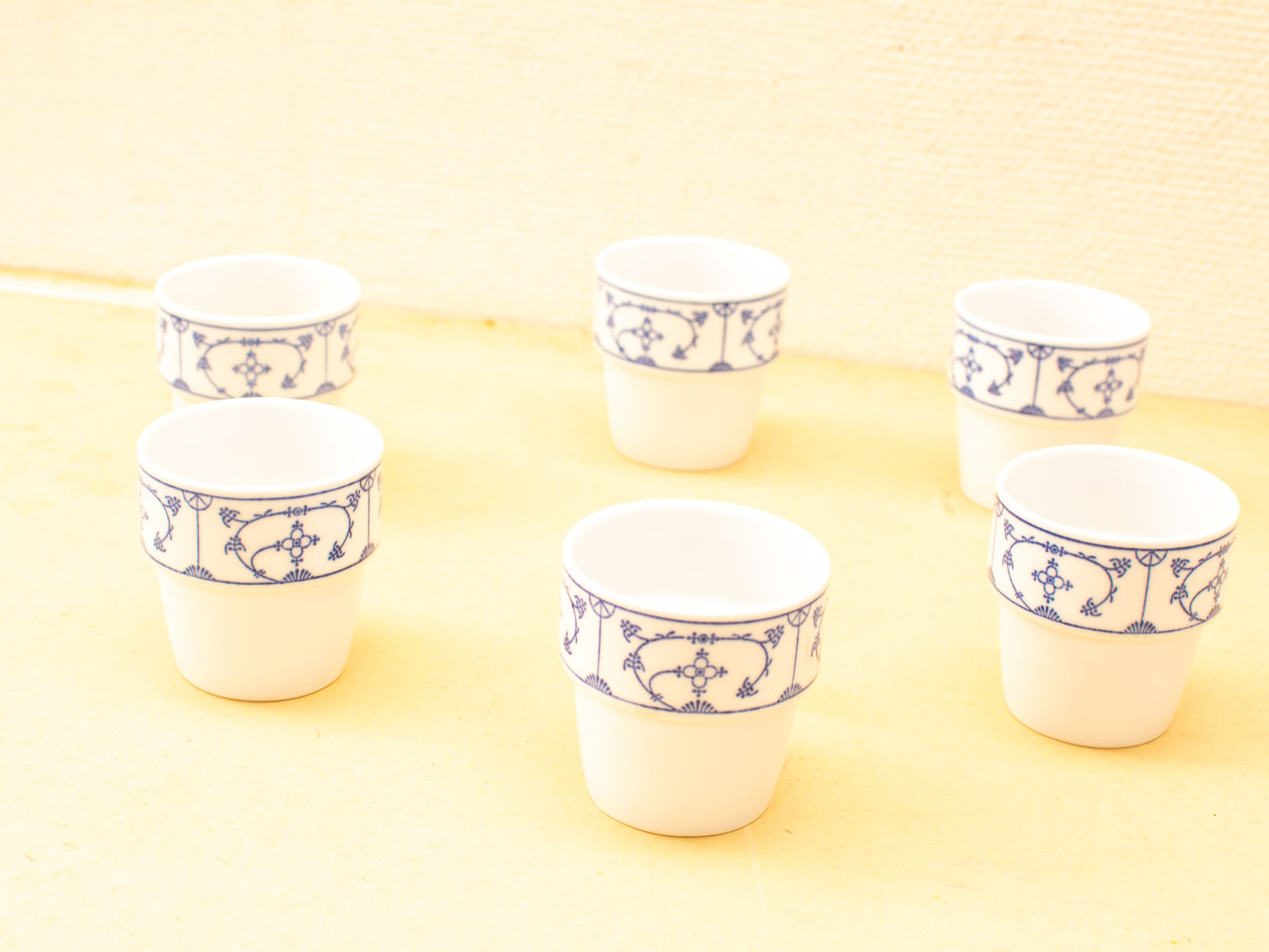 Elegant white ceramic cups with blue patterns, perfect for vintage dining and charming table settings.