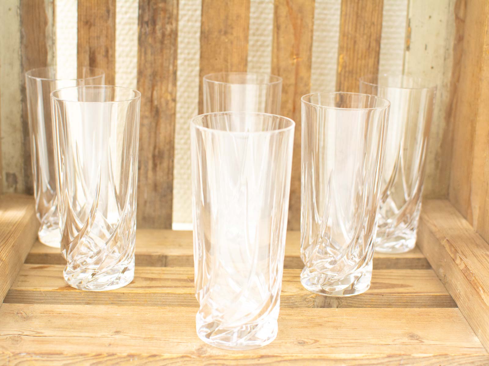 Elegant twisted glasses on rustic wood create a warm, inviting dining atmosphere.