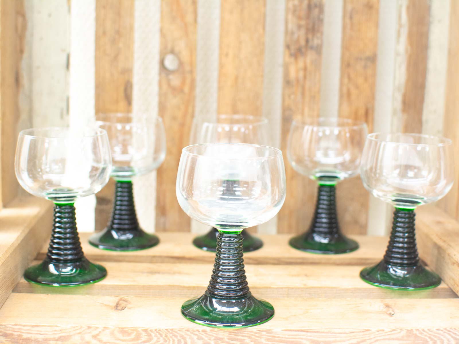 Elegant vintage glasses on a rustic wooden crate, perfect for stylish gatherings and decor.