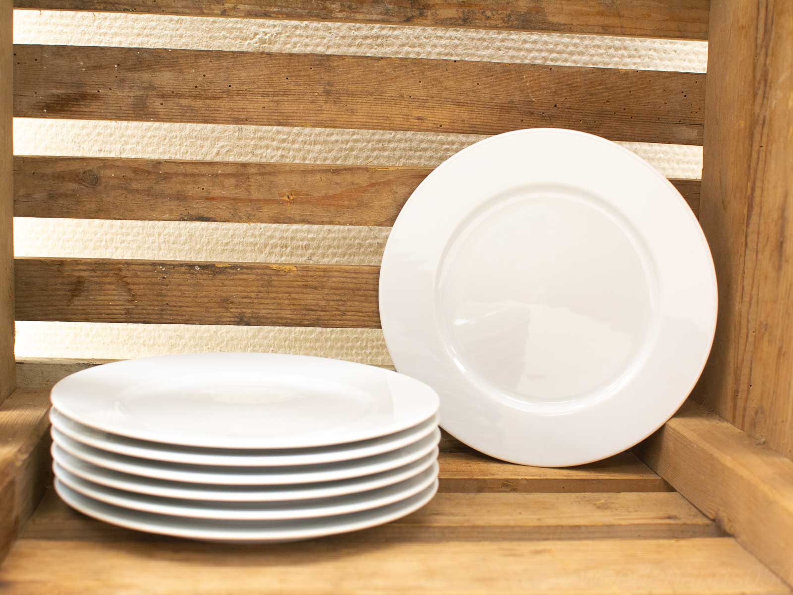 Elegant white plates on rustic wood, perfect for inviting dining experiences.