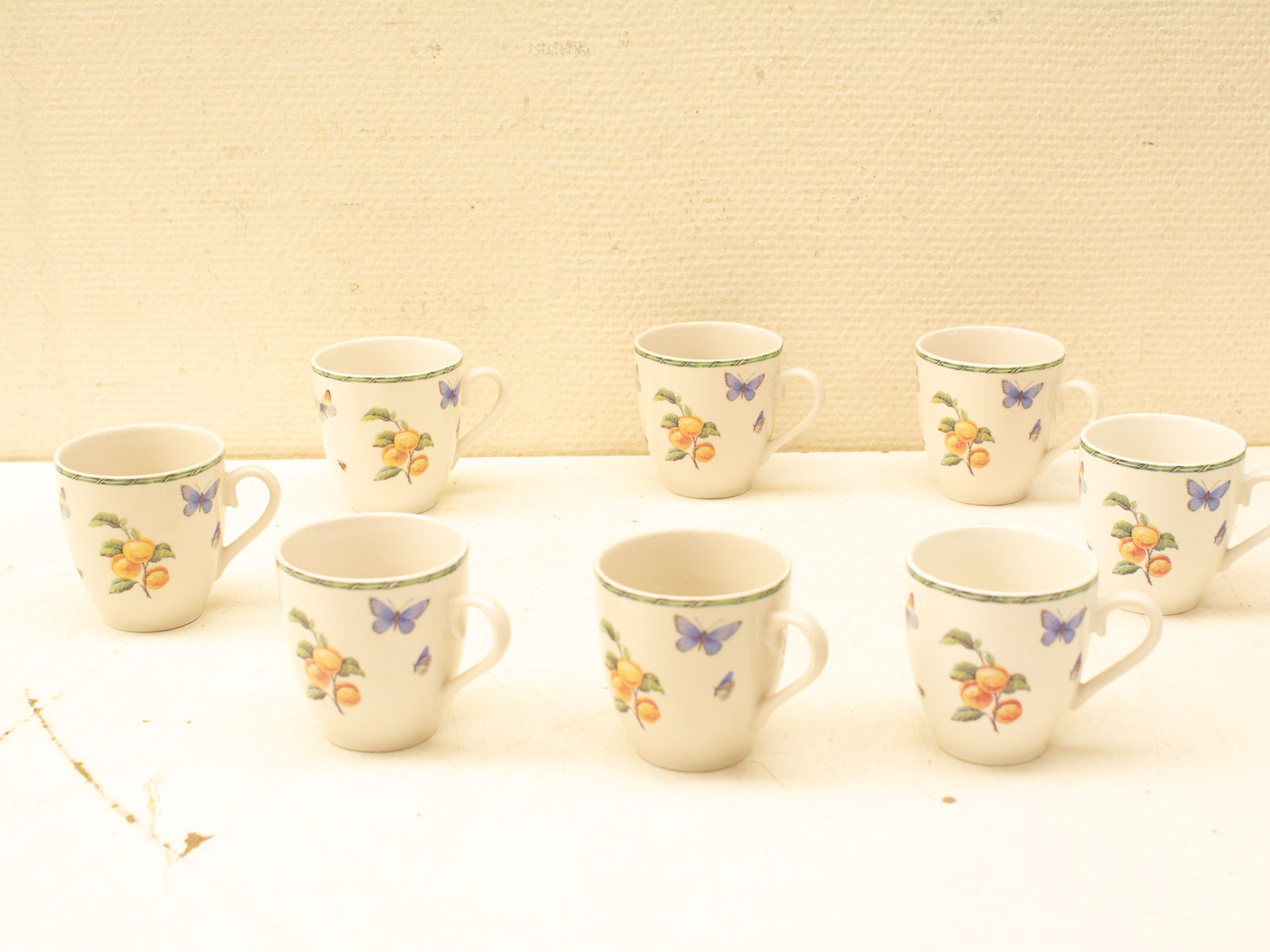 Charming vintage ceramic cups with floral and butterfly designs, perfect for tea or espresso.