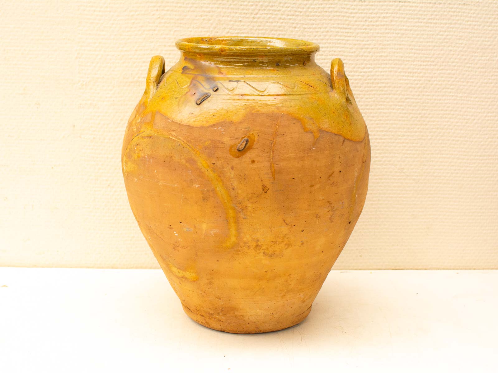 Handcrafted clay pot with glossy glaze, elegant handles, and unique decorative patterns.