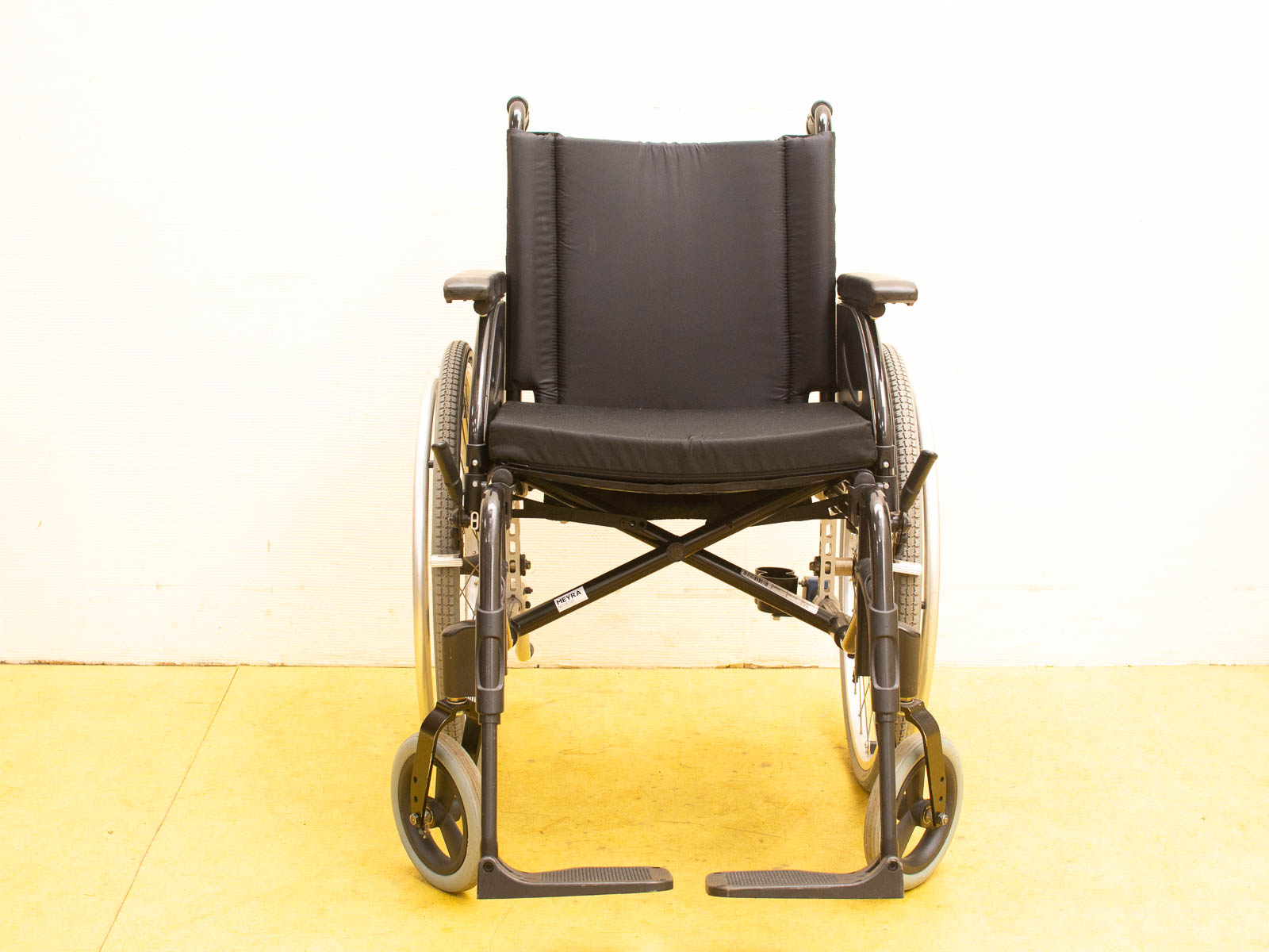 Comfortable traditional wheelchair with black cushion for mobility and support in daily activities.