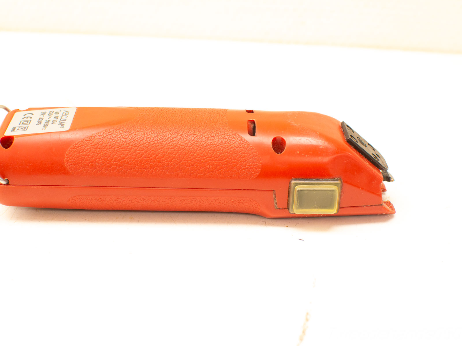 Sleek ergonomic orange electric trimmer with precision blade for comfortable grooming and adjustable lengths.