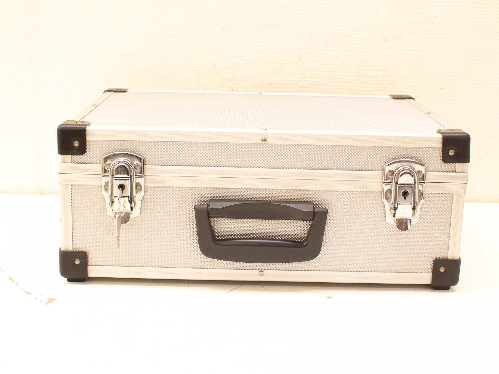 Durable metallic briefcase with locks and ergonomic handle for secure professional storage.