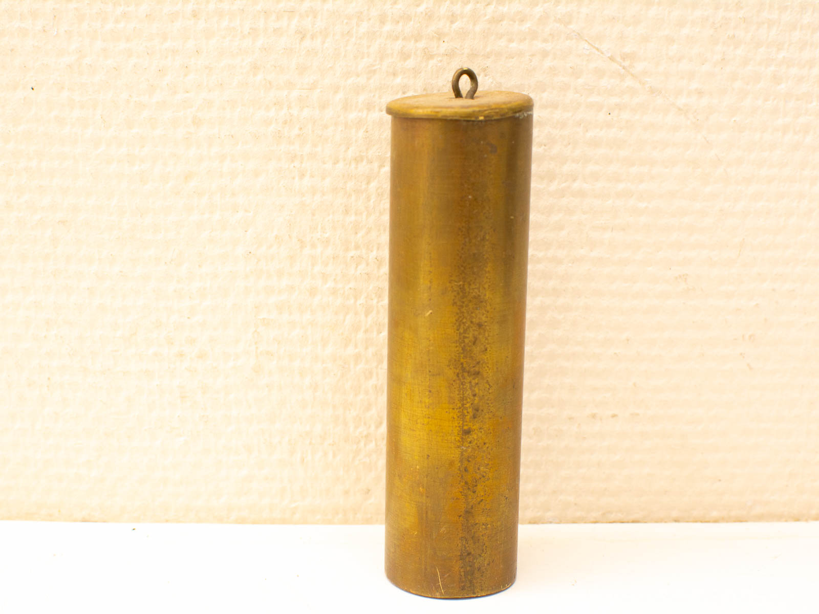 Vintage brass cylinder with loop, showcasing elegant design and charming patina for collectors.