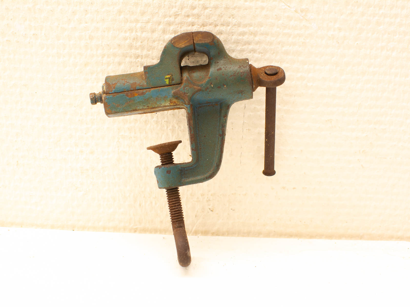 Rustic teal clamp tool with vintage charm and rusty details, perfect for collectors and decor.