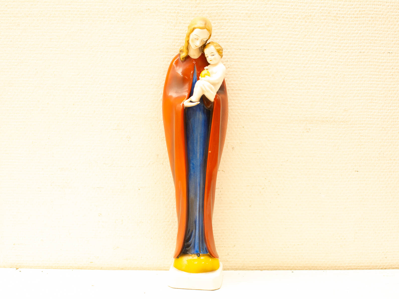 Vintage mother and child figurine symbolizing love, care, and maternal devotion in vibrant colors.