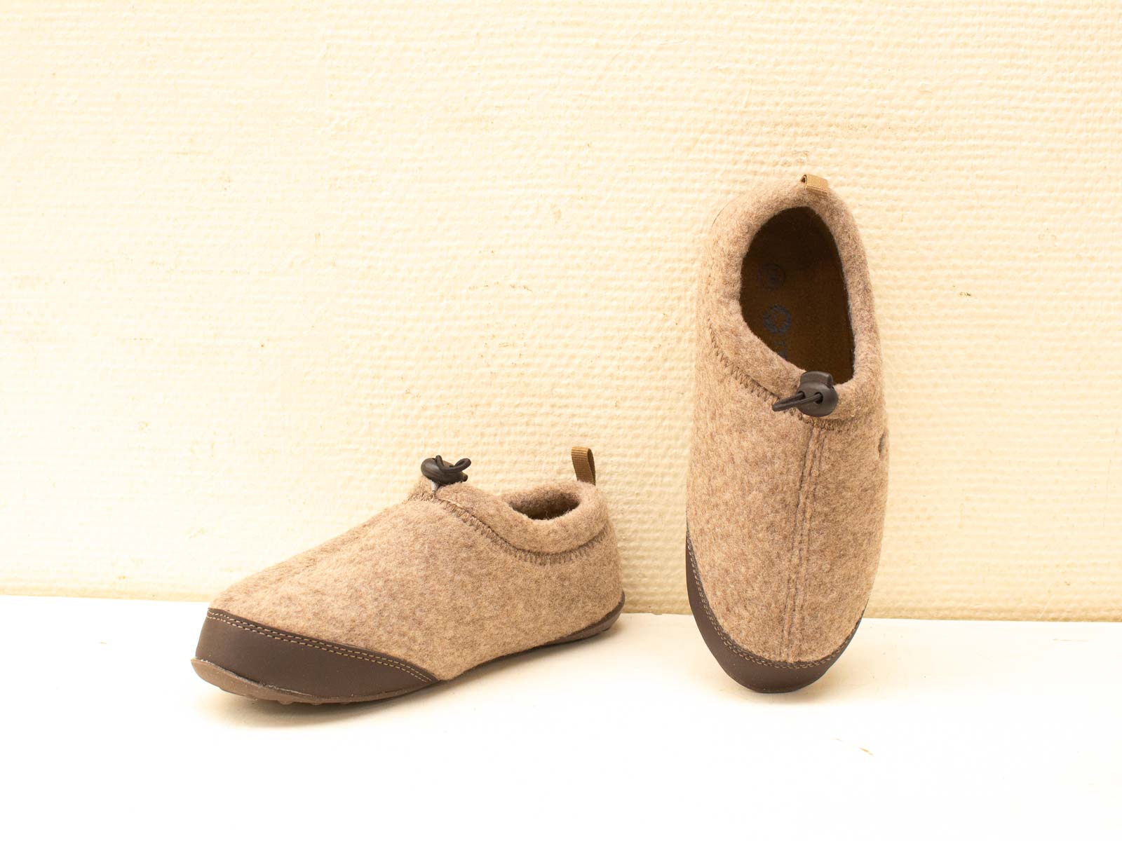 Comfortable beige wool slippers with toggle fasteners, perfect for lounging and cozy evenings.