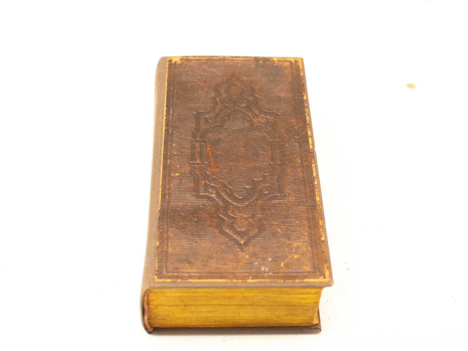 Aged leather book with gilt edges, showcasing embossed details and timeless elegance for collectors.