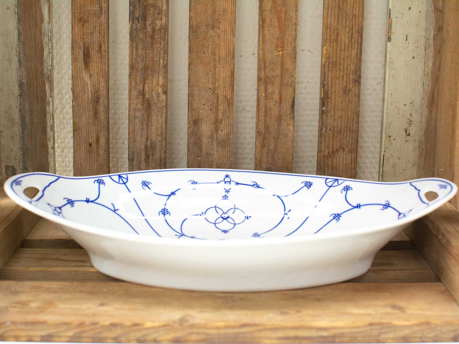 Elegant oval porcelain dish with blue patterns, ideal for serving and decorating.