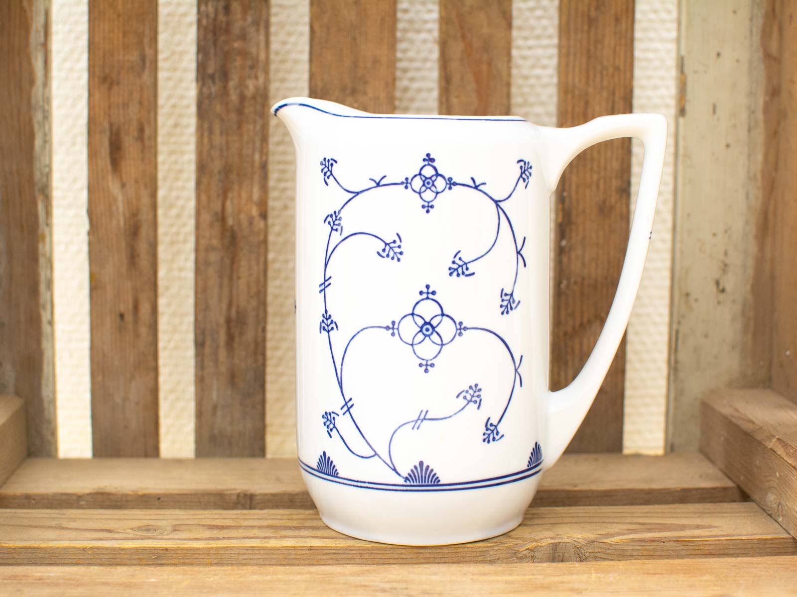 Elegant vintage ceramic pitcher with blue floral patterns, perfect for charming dining spaces.