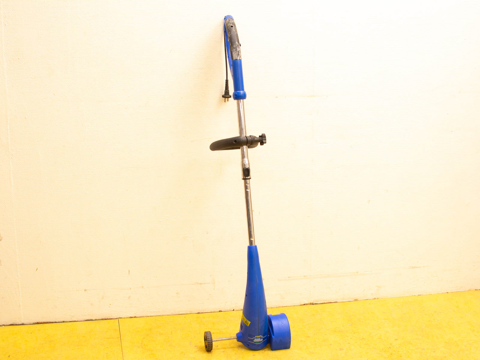 Used blue electric trimmer for gardening, ergonomic design, reliable performance, and easy maneuverability.