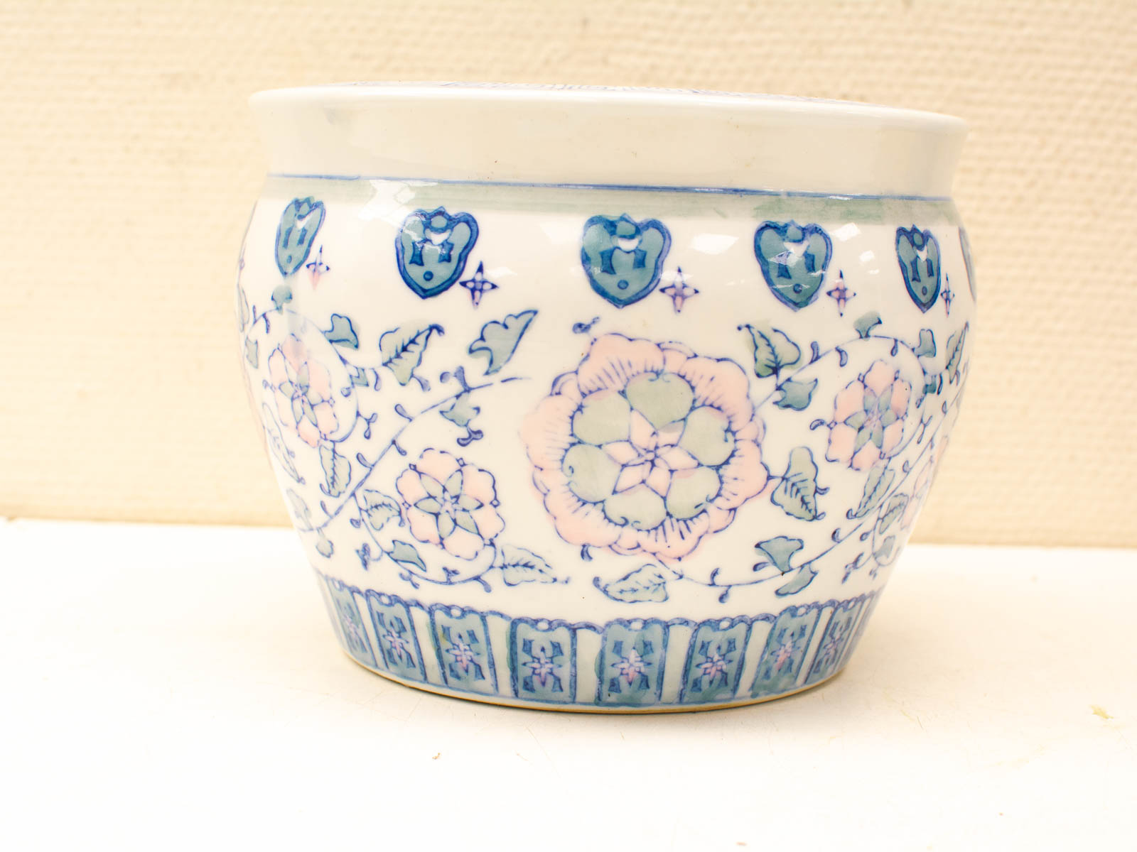 Elegant pastel ceramic pot with floral design and geometric patterns, perfect for decor or planting.