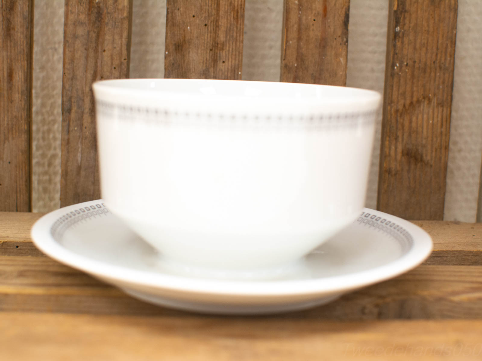 Elegant ceramic bowl and saucer set on rustic wood, perfect for stylish dining occasions.