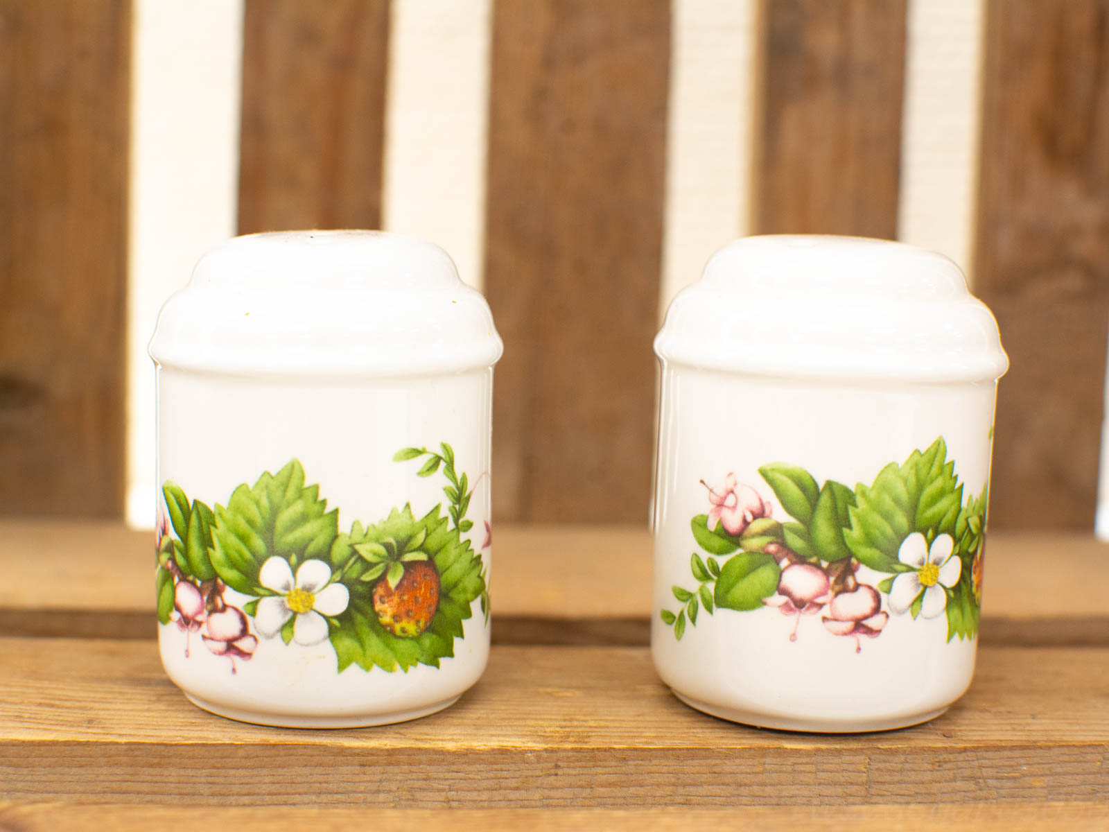 Charming porcelain containers with botanical designs, perfect for spices and kitchen decor.