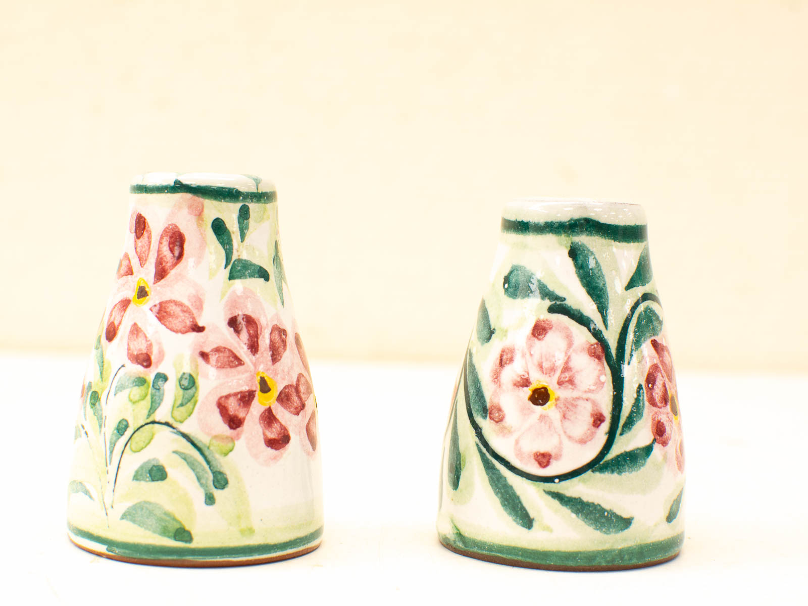 Charming ceramic vessels with vibrant floral designs, perfect for decoration or functional use.