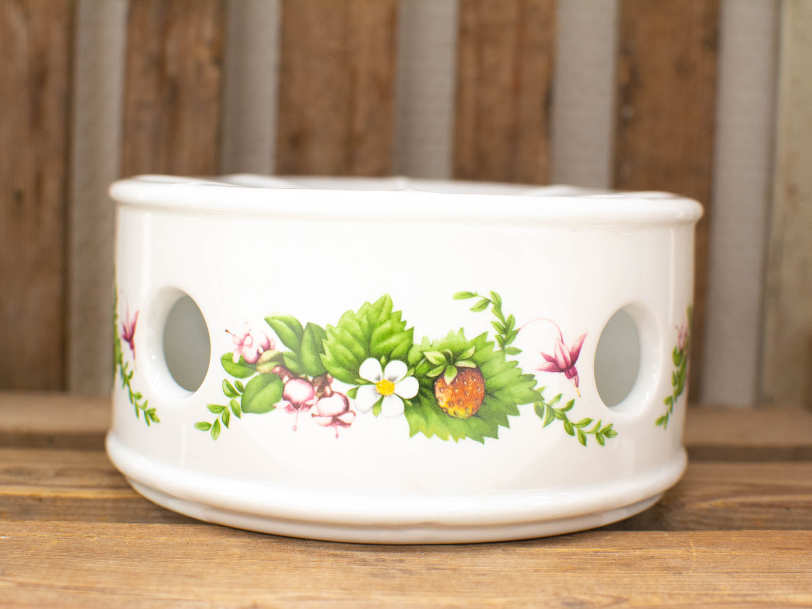 Elegant ceramic planter with vibrant floral designs, perfect for plants or stylish decor.