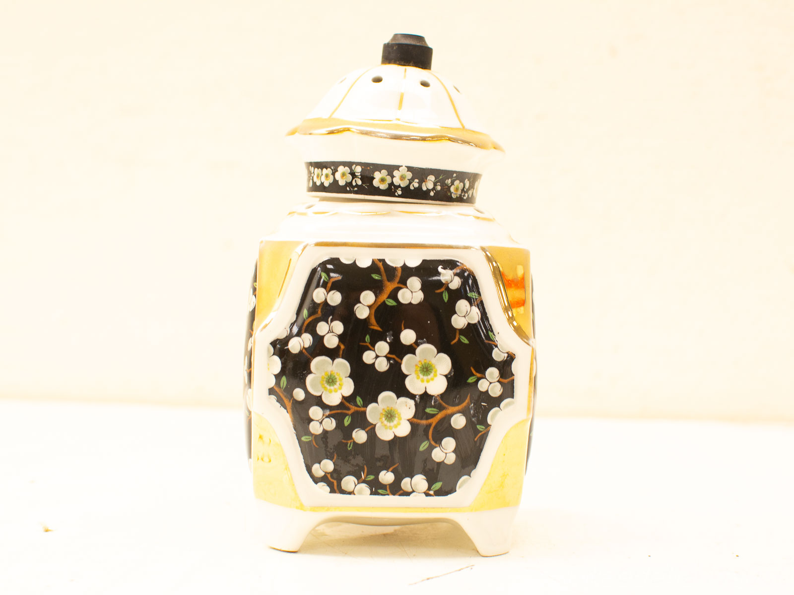 Elegant ceramic jar with floral patterns and gold accents, perfect for display and functionality.