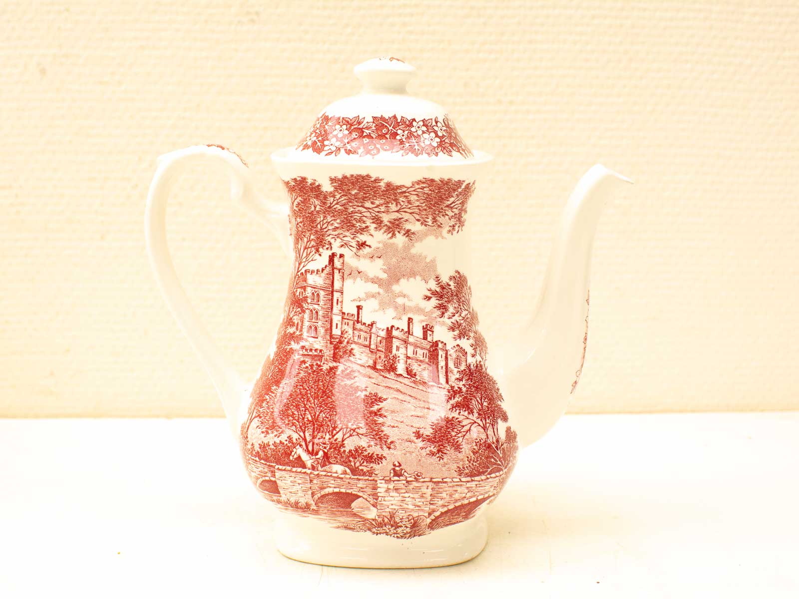 Elegant vintage teapot with intricate red landscape design, perfect for collectors and decor.