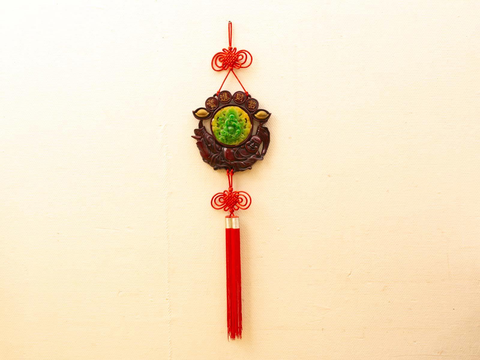 Elegant Chinese jade ornament with red cord and tassel, symbolizing prosperity and good fortune.