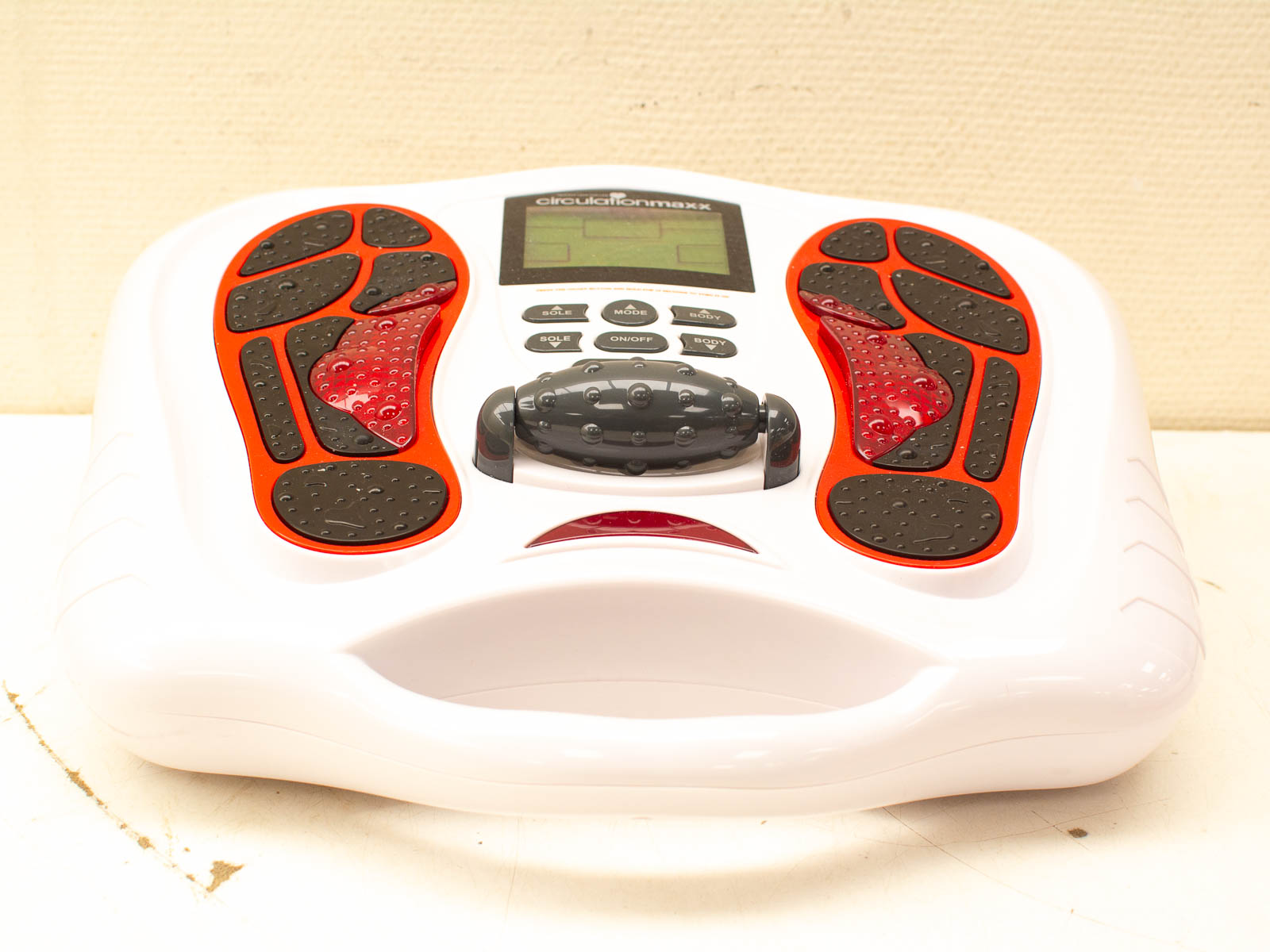 Sleek white foot massager with red pads for customized relaxation and comfort at home.