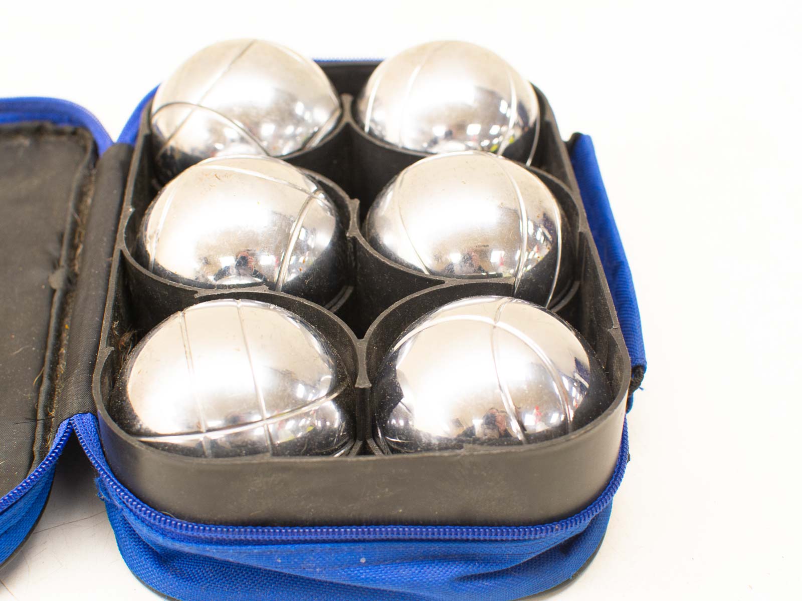 Stylish blue case for six metallic balls, perfect for pétanque and outdoor games.