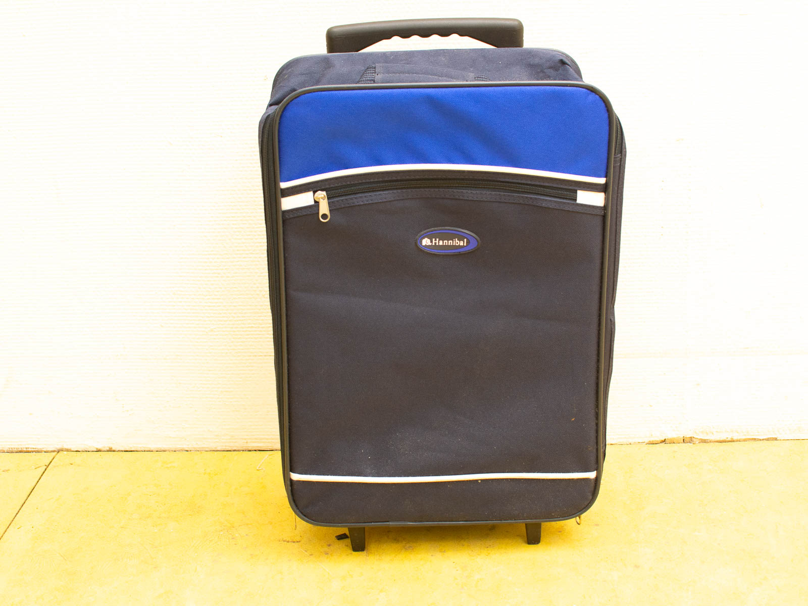 Stylish navy blue suitcase with wheels, durable design, front pocket, and telescoping handle.