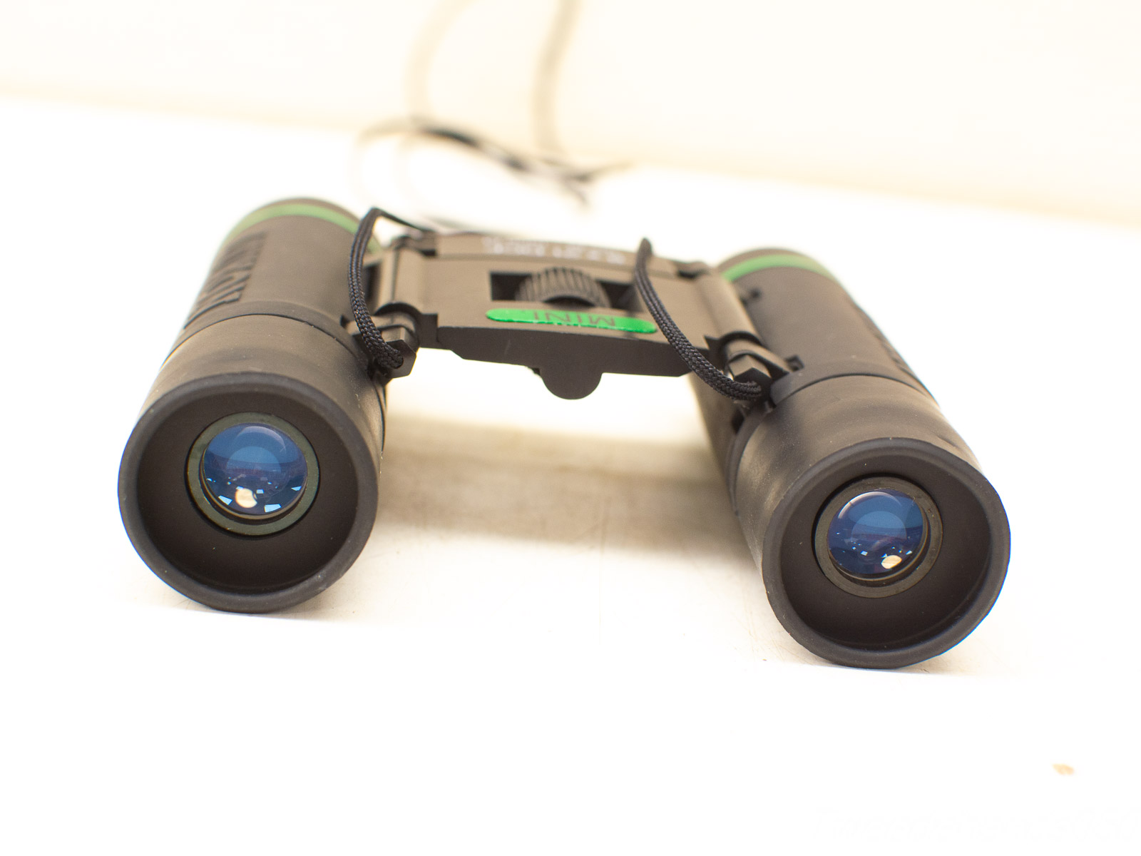 Compact binoculars with green accents, perfect for outdoor adventures and enhanced image clarity.