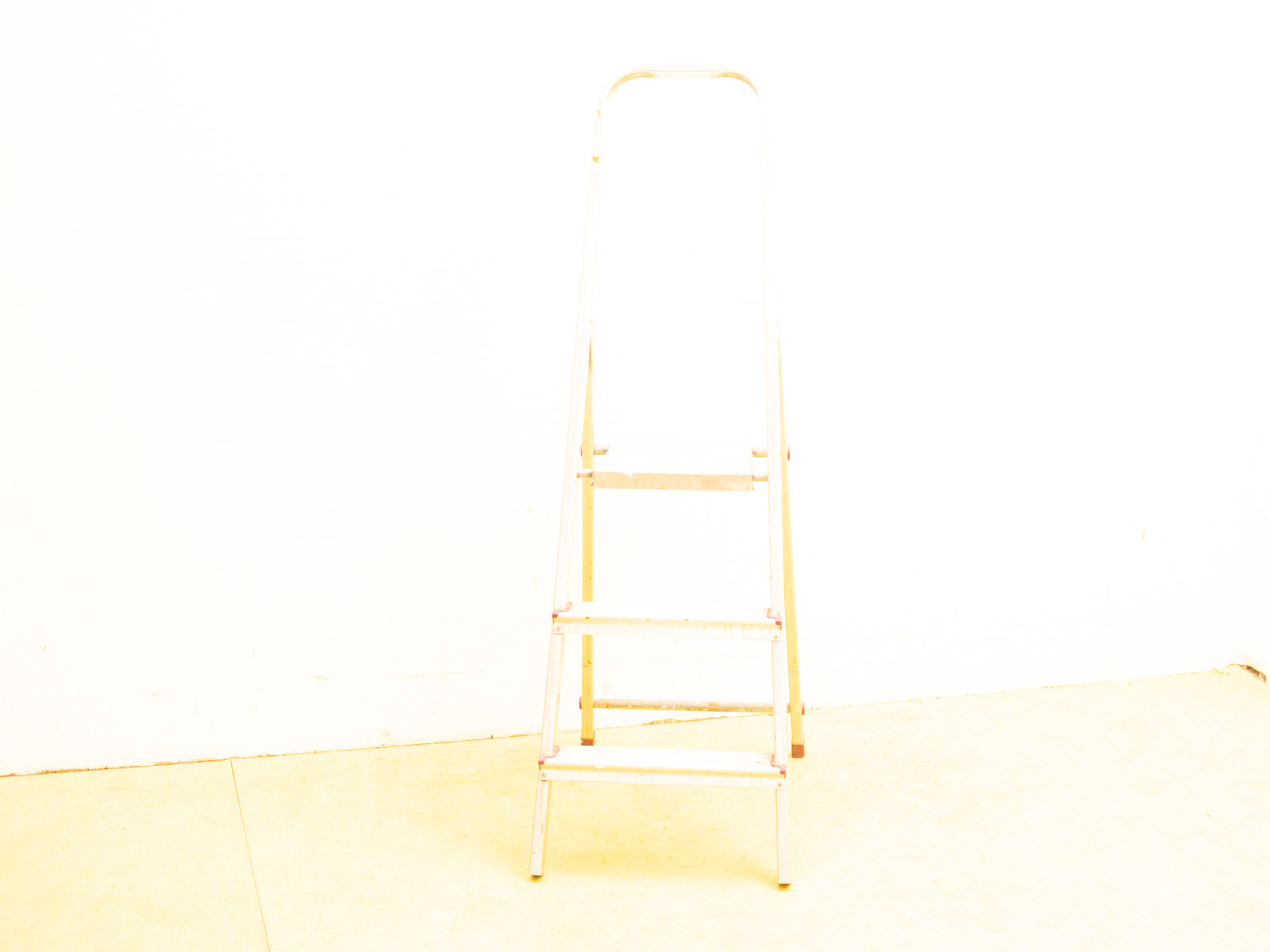 Sleek aluminum step ladder on a bright white background, perfect for reaching high places.