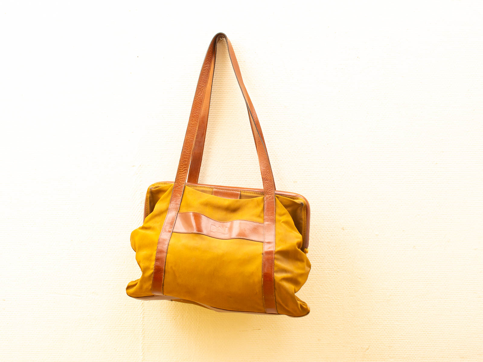 Vibrant yellow handbag with brown leather straps, perfect for stylish and versatile accessorizing.