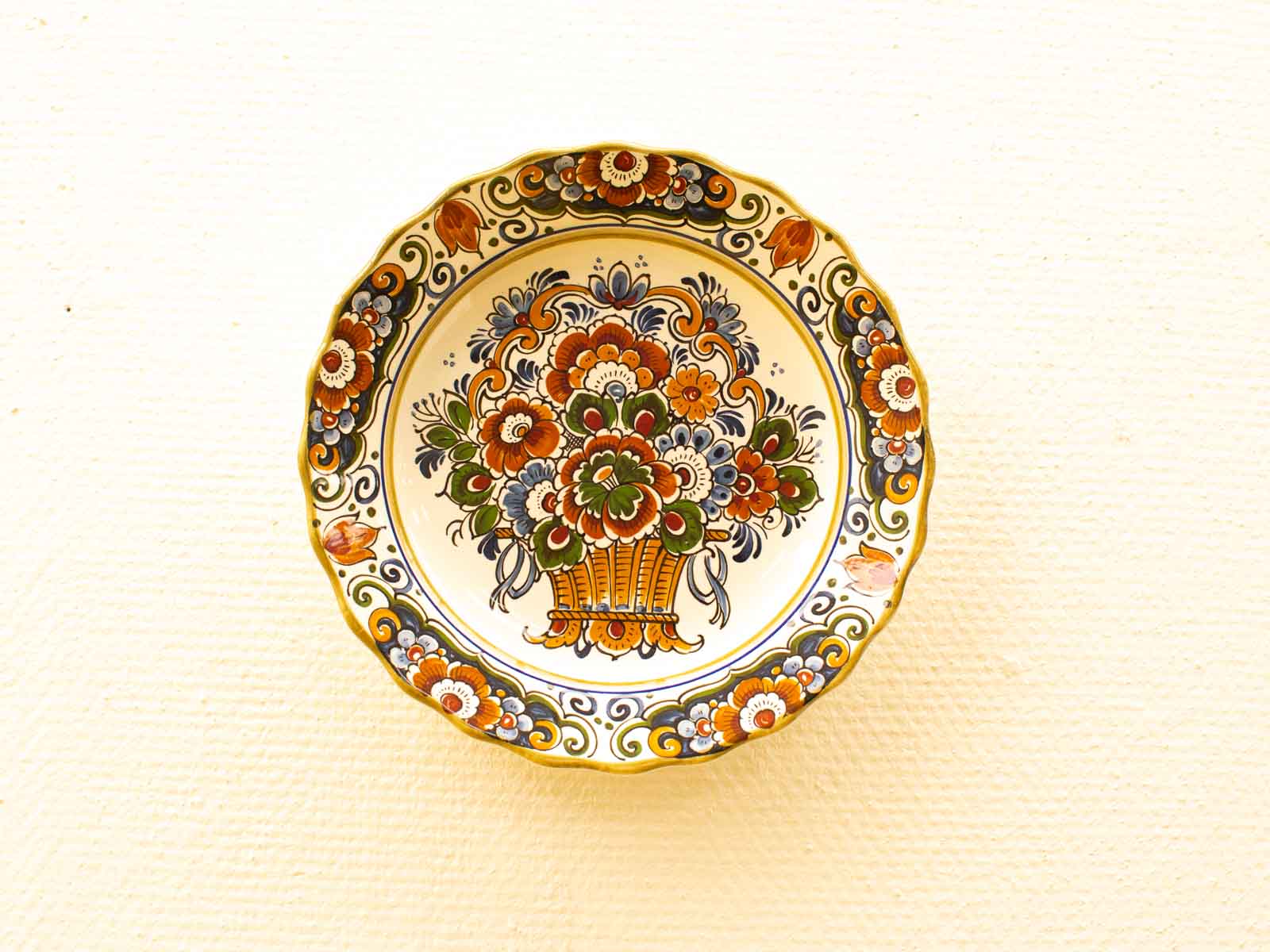 Vibrant hand-painted vintage floral plate with scalloped edges, perfect for home decor display.