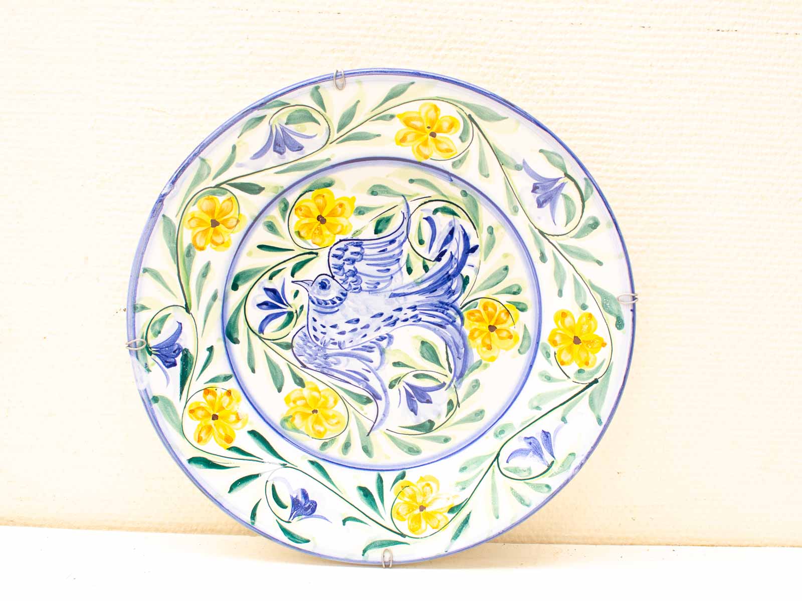 Vibrant hand-painted plate with a bird and floral designs, perfect for home decor.