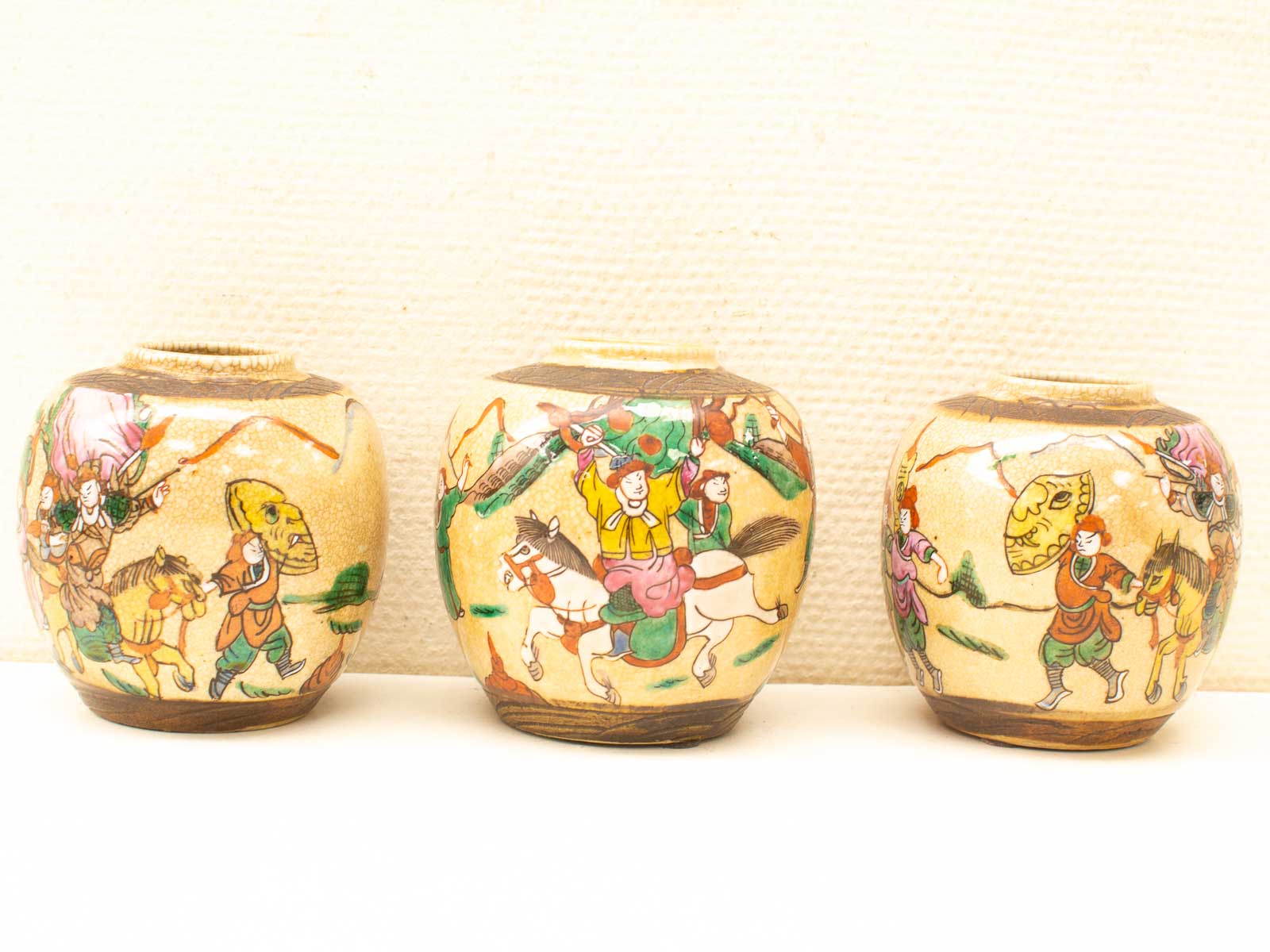 Vibrant decorative jars featuring intricate traditional scenes and lively cultural storytelling.