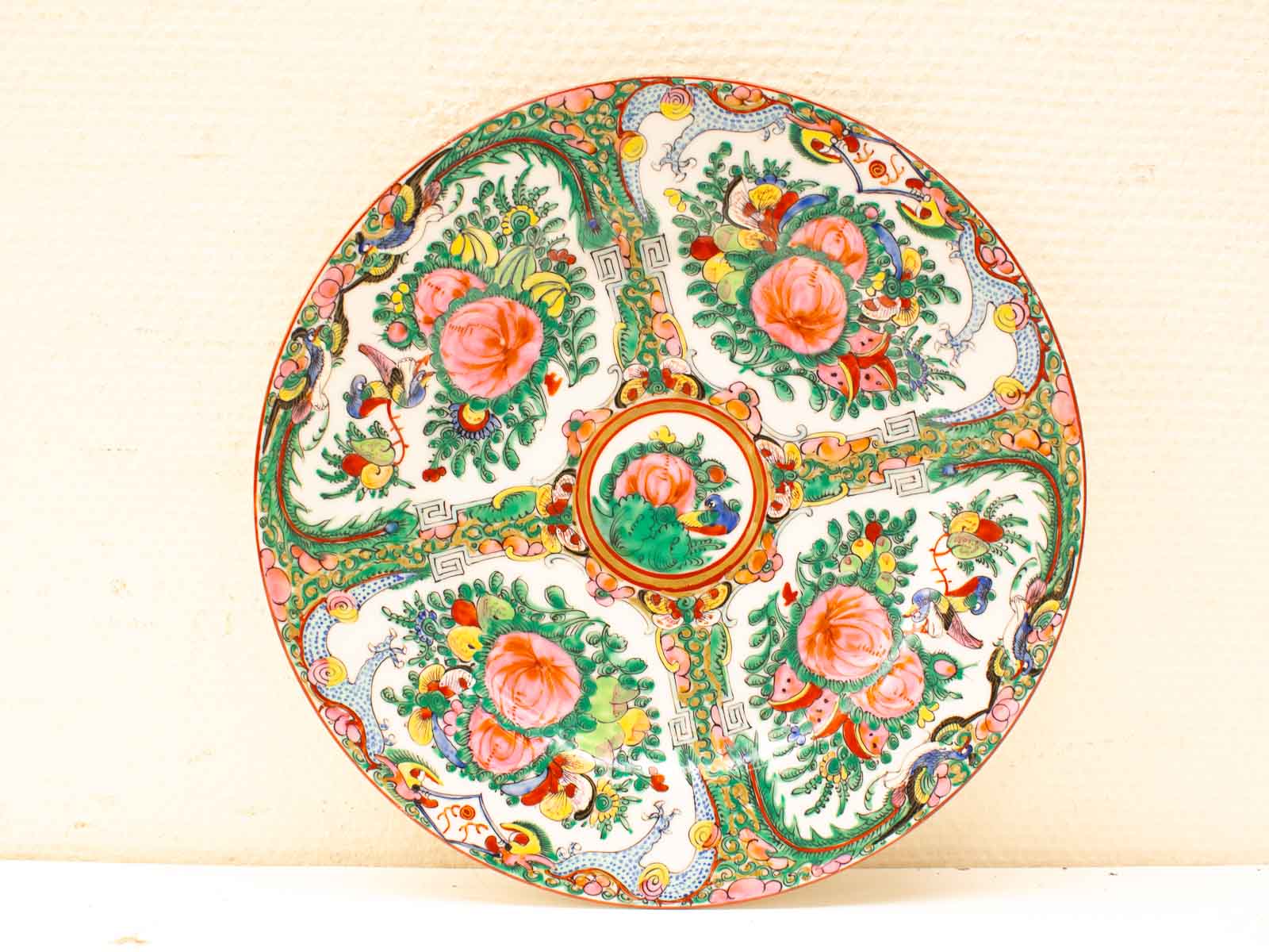 Vibrant porcelain plate with intricate floral and bird designs, perfect for decorative display.