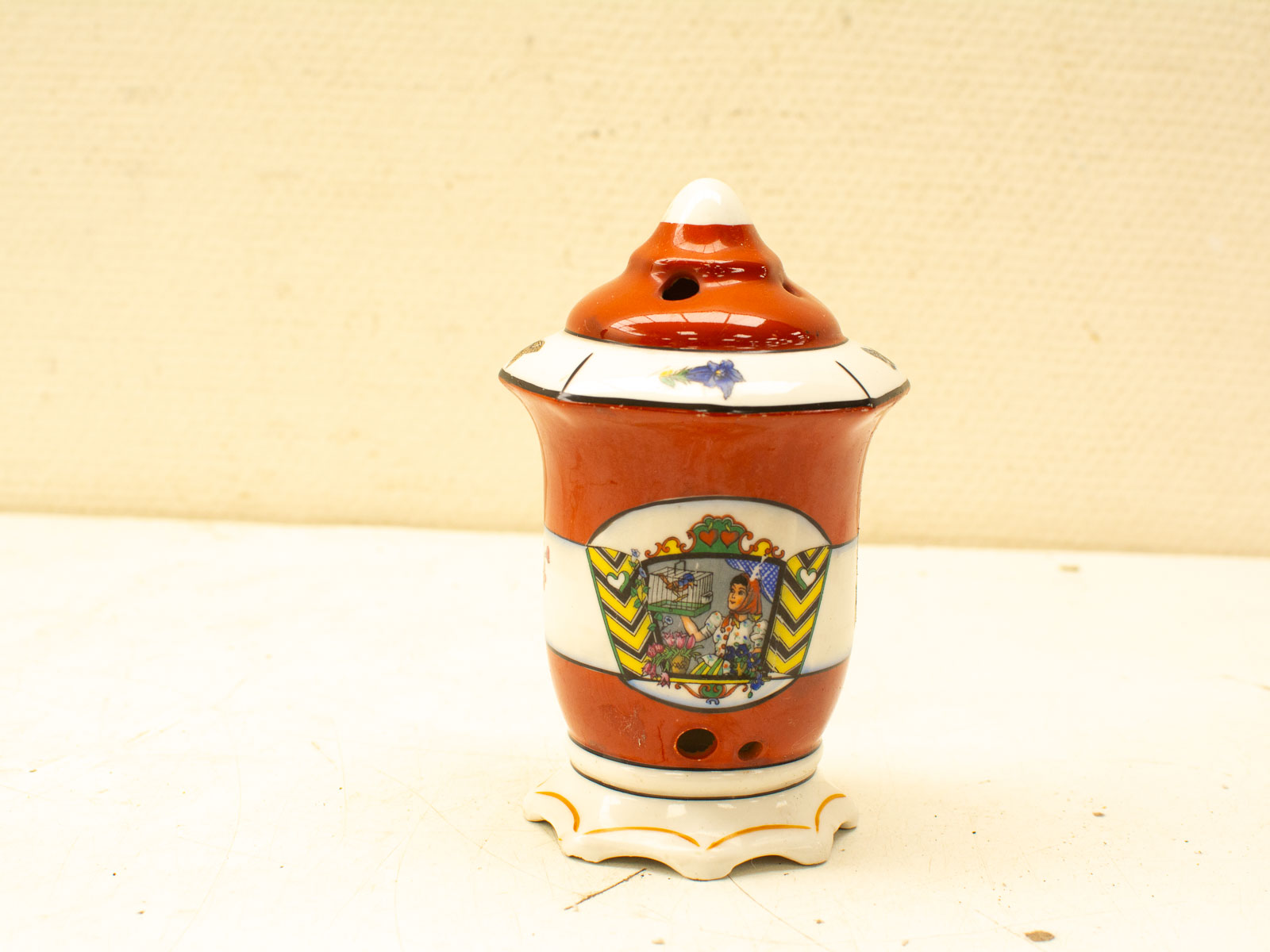 Vibrant porcelain urn with floral scene, intricate patterns, and exquisite craftsmanship.