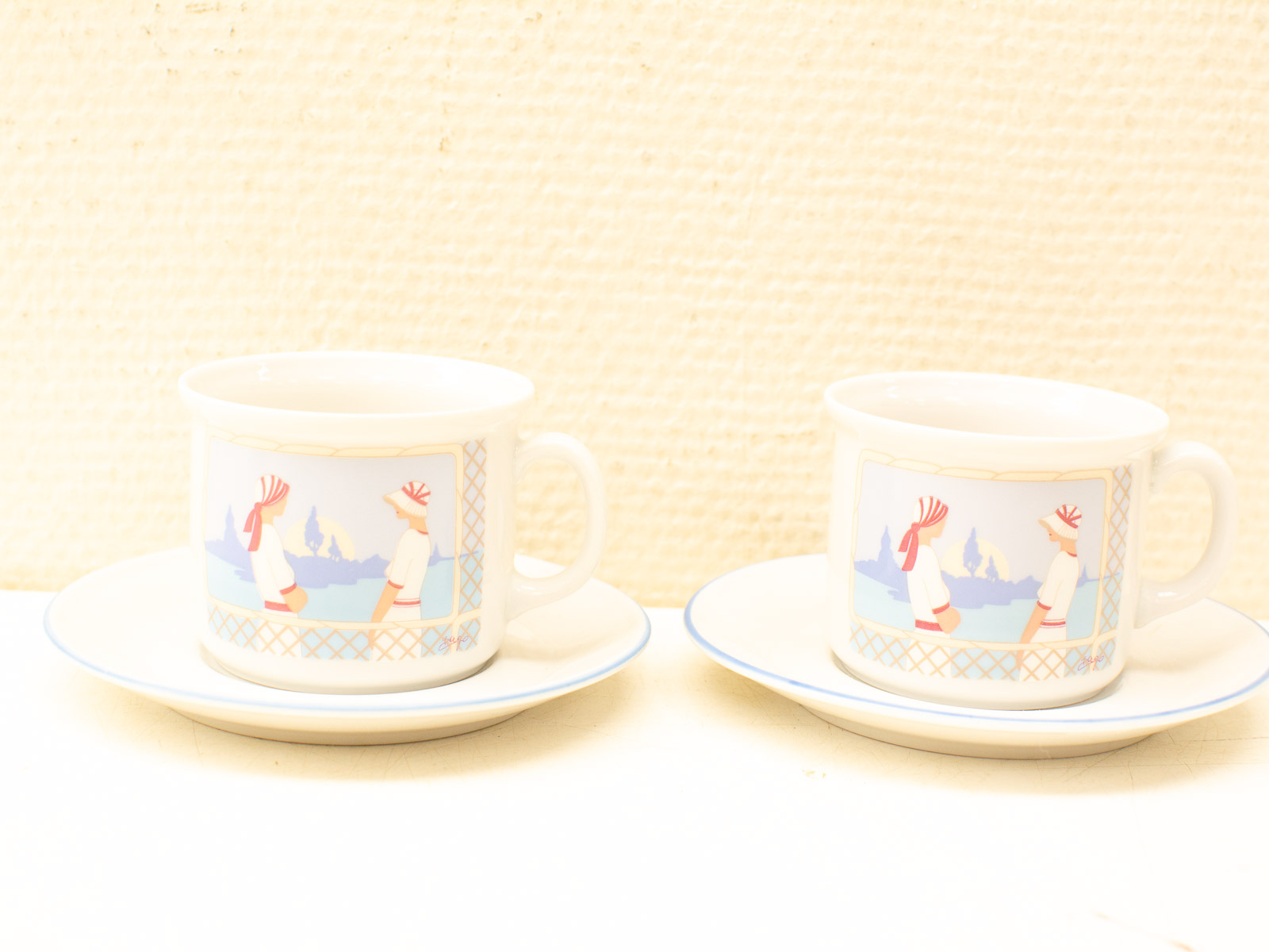 Charming porcelain teacups with whimsical waterfront scenes, perfect for tea time or decor.