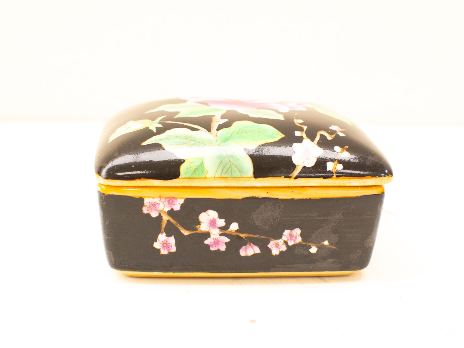 Elegant black lacquer box adorned with cherry blossoms and gold trim for sophisticated decor.