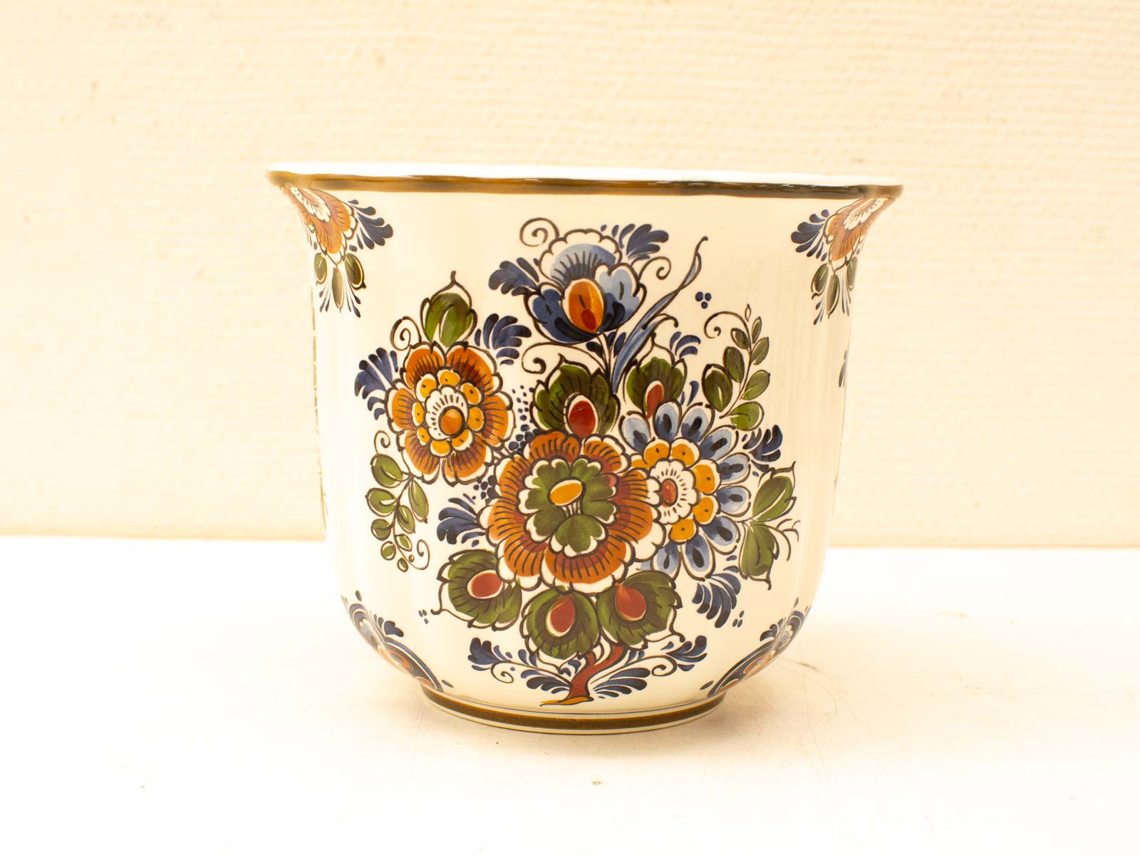 Elegant vintage ceramic pot with vibrant floral design and golden accents. Perfect for decor.