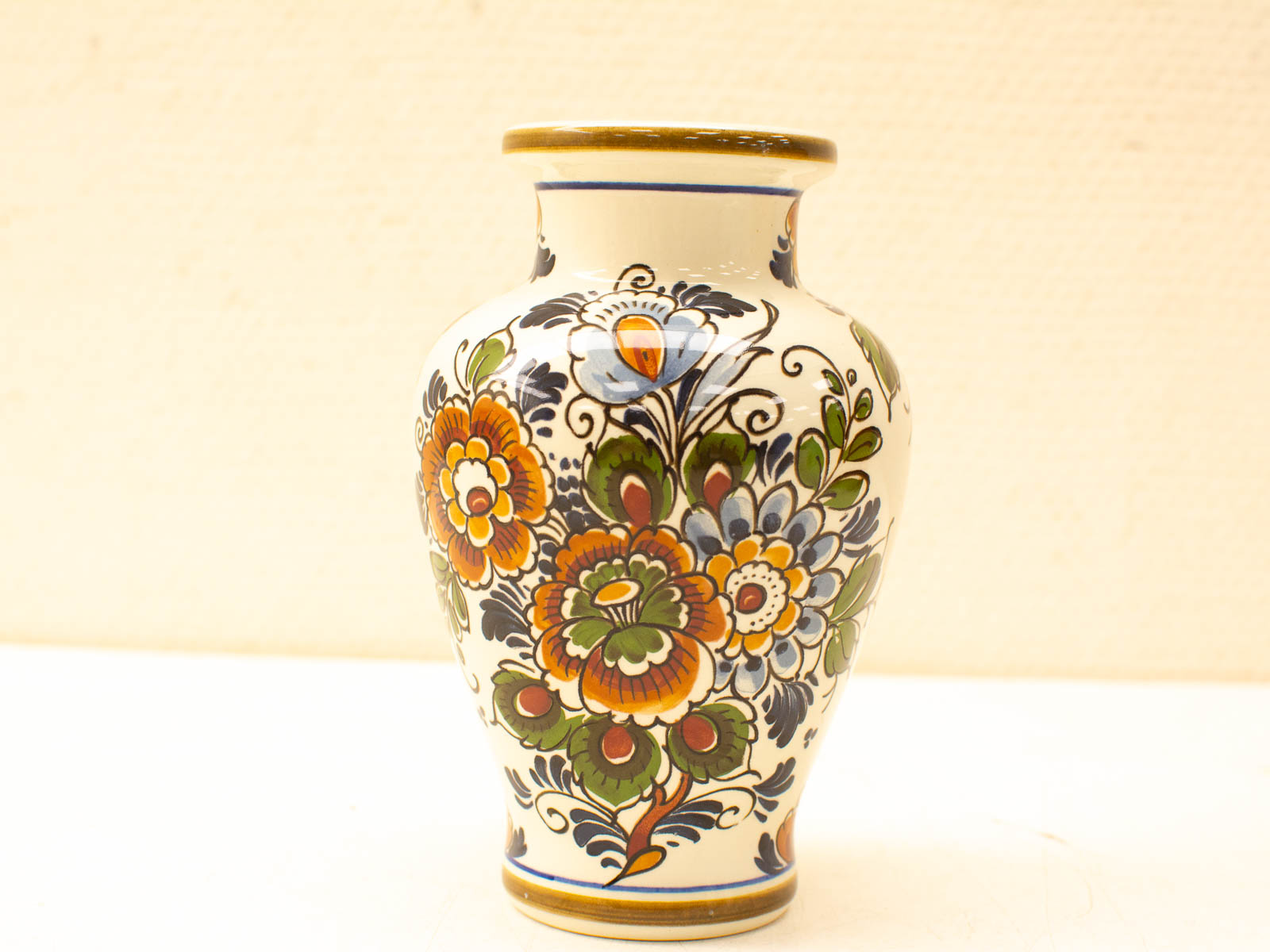 Elegant ceramic vase with colorful floral designs in orange, blue, and green. Perfect for decor.