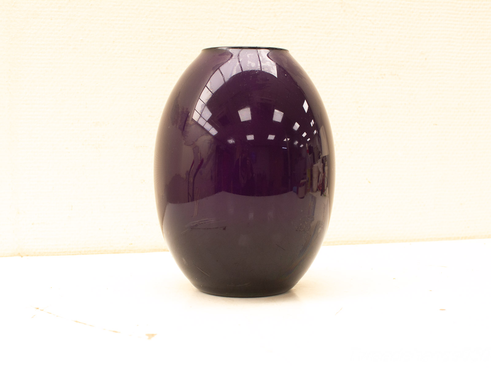 Handcrafted deep purple oval glass vase, perfect as a decorative centerpiece for any space.